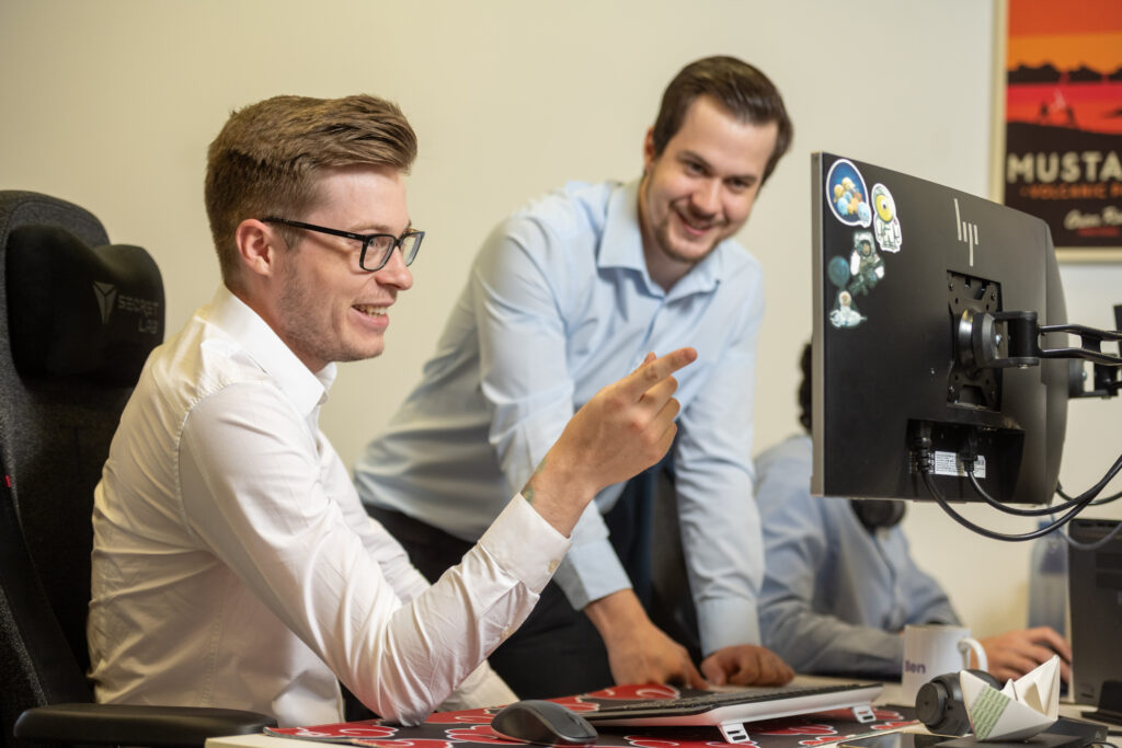 2 Team members at techwyse looking at a desktop computer screen