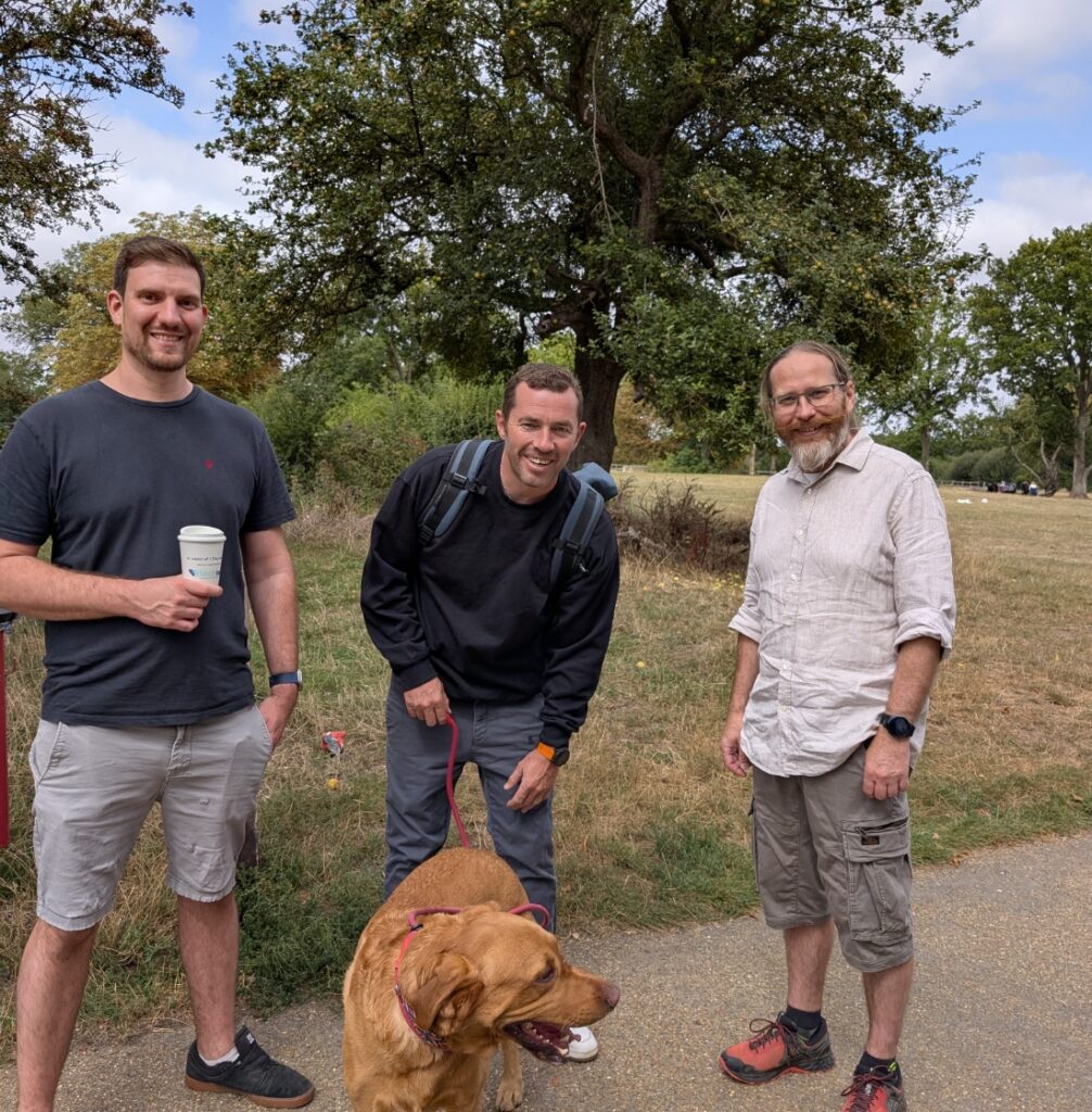 3 Men in a field with a dog